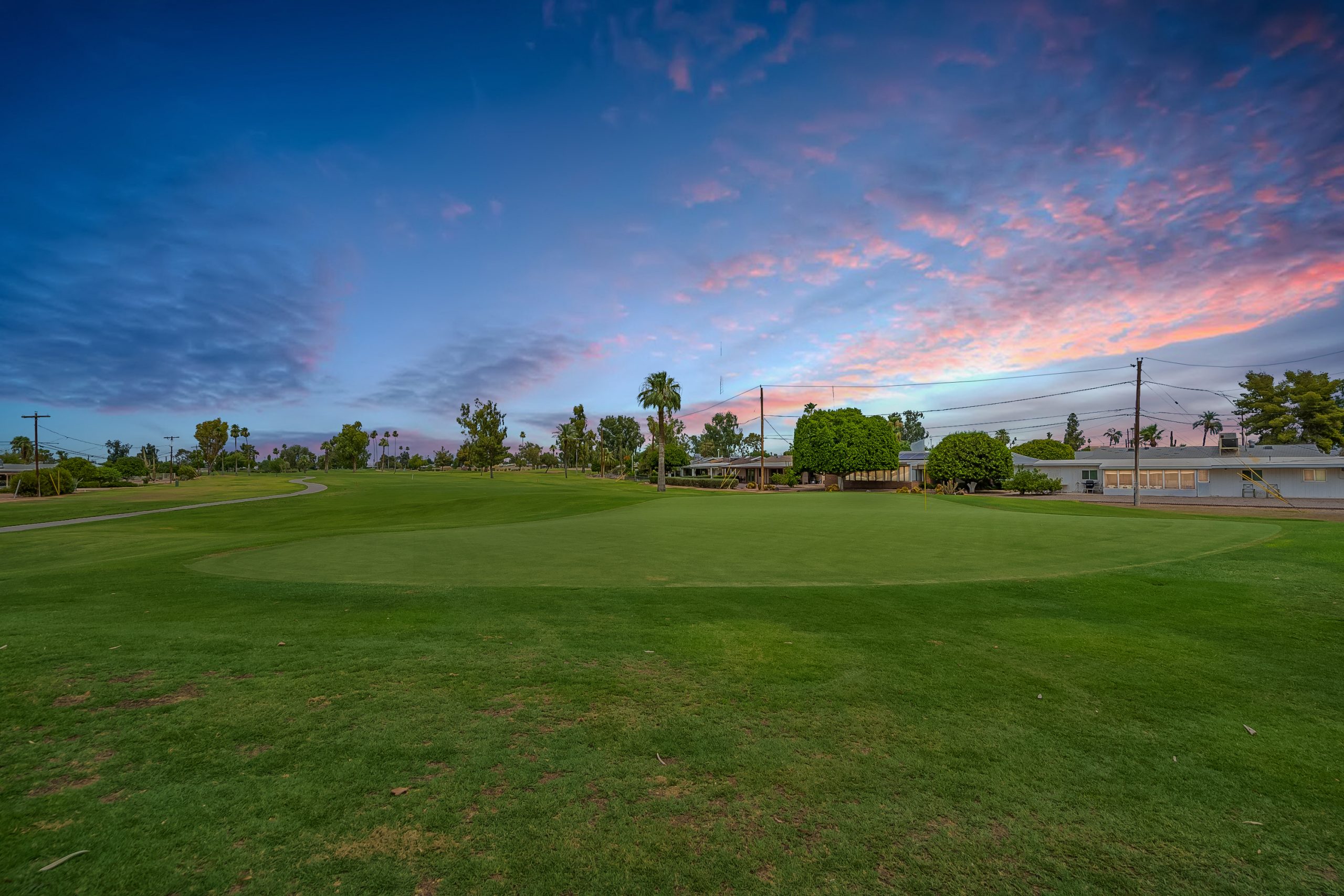 Single-story Arizona home photographed at twilight with mature landscaping