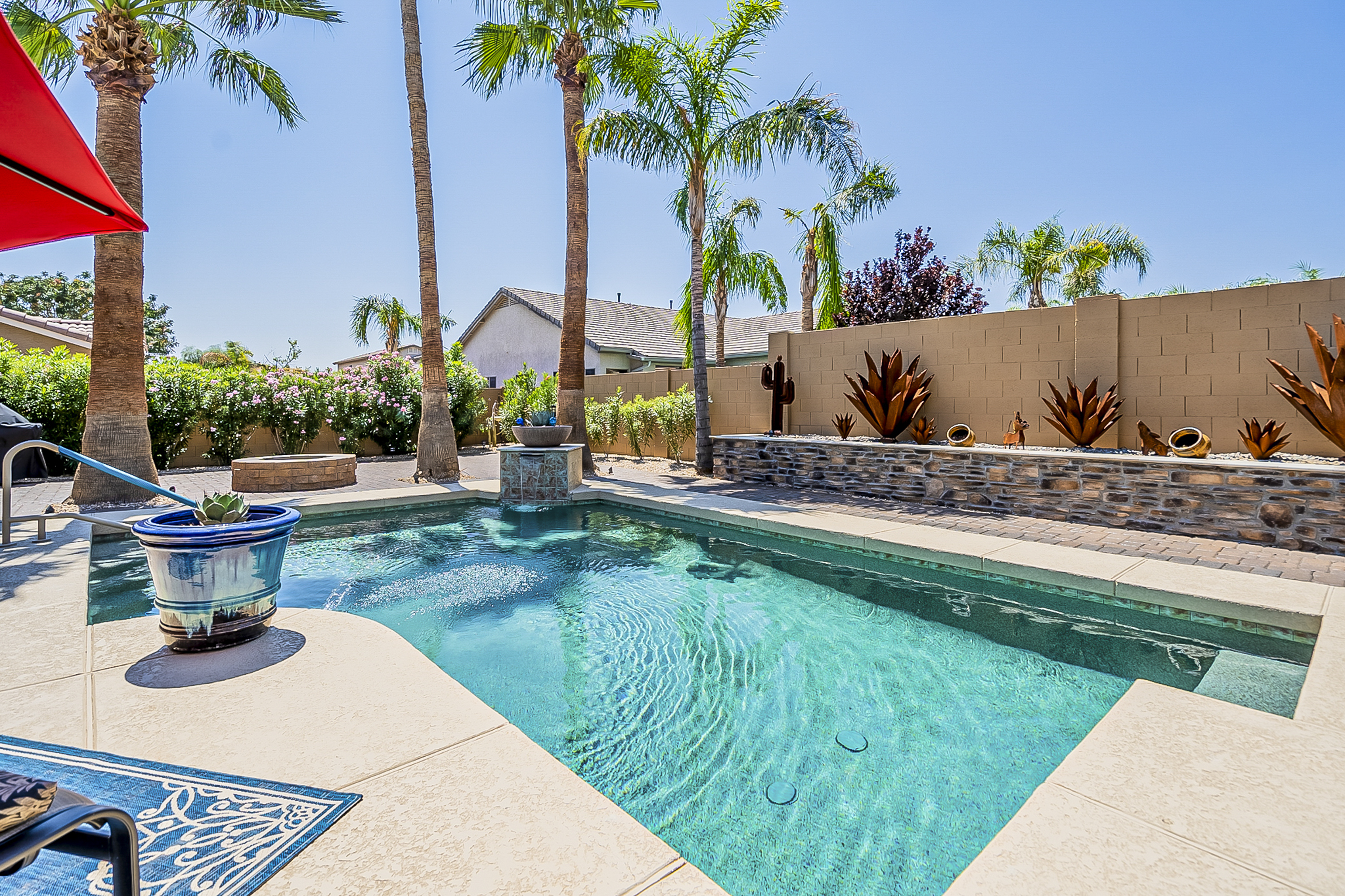 Landscaped Arizona backyard with a swimming pool and palm trees